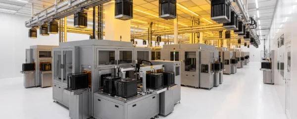 Fully automated semiconductor cleanroom with robotic equipment and EFEM systems handling wafer containers under yellow lighting with no human presence